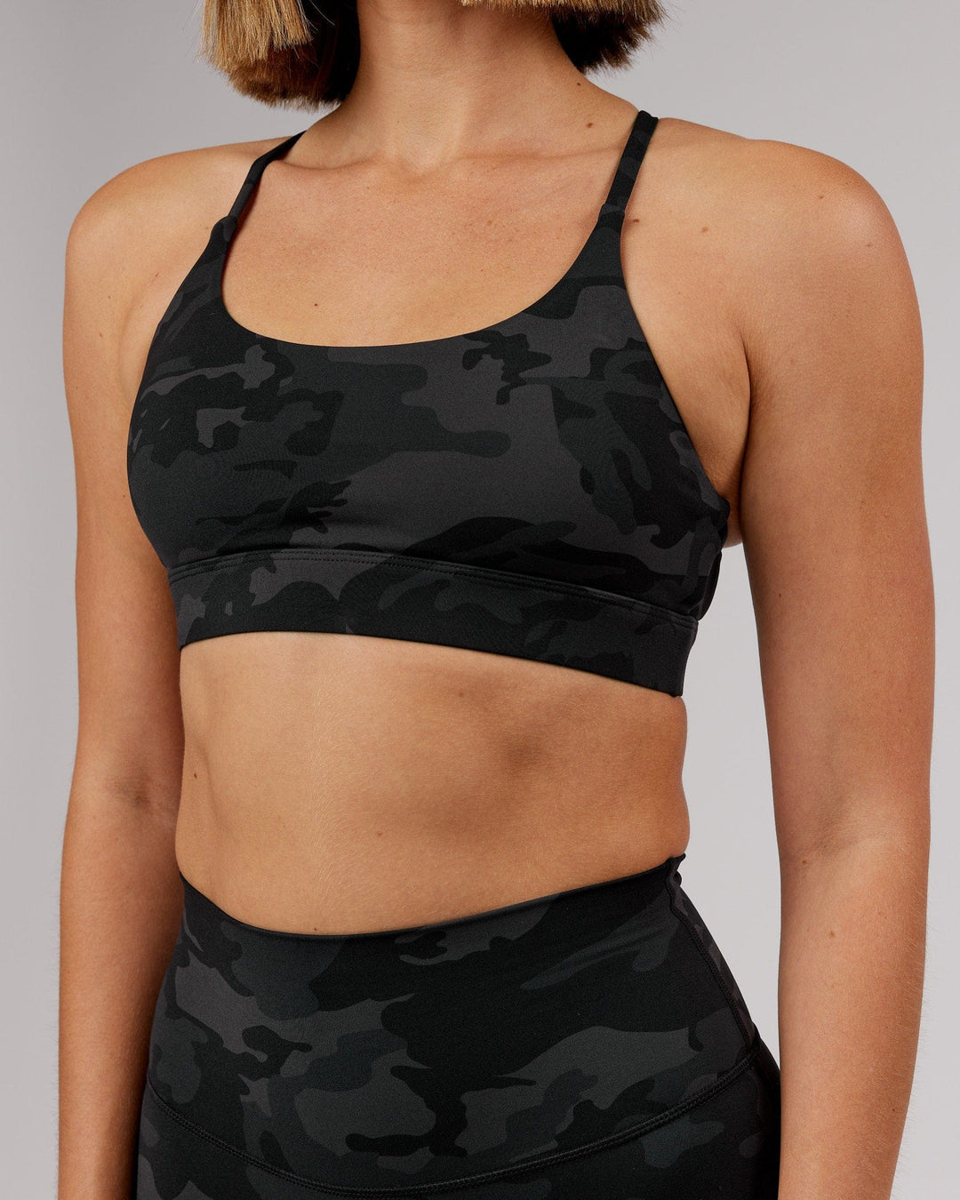 Woman wearing Elixir Sports Bra - Black Camo