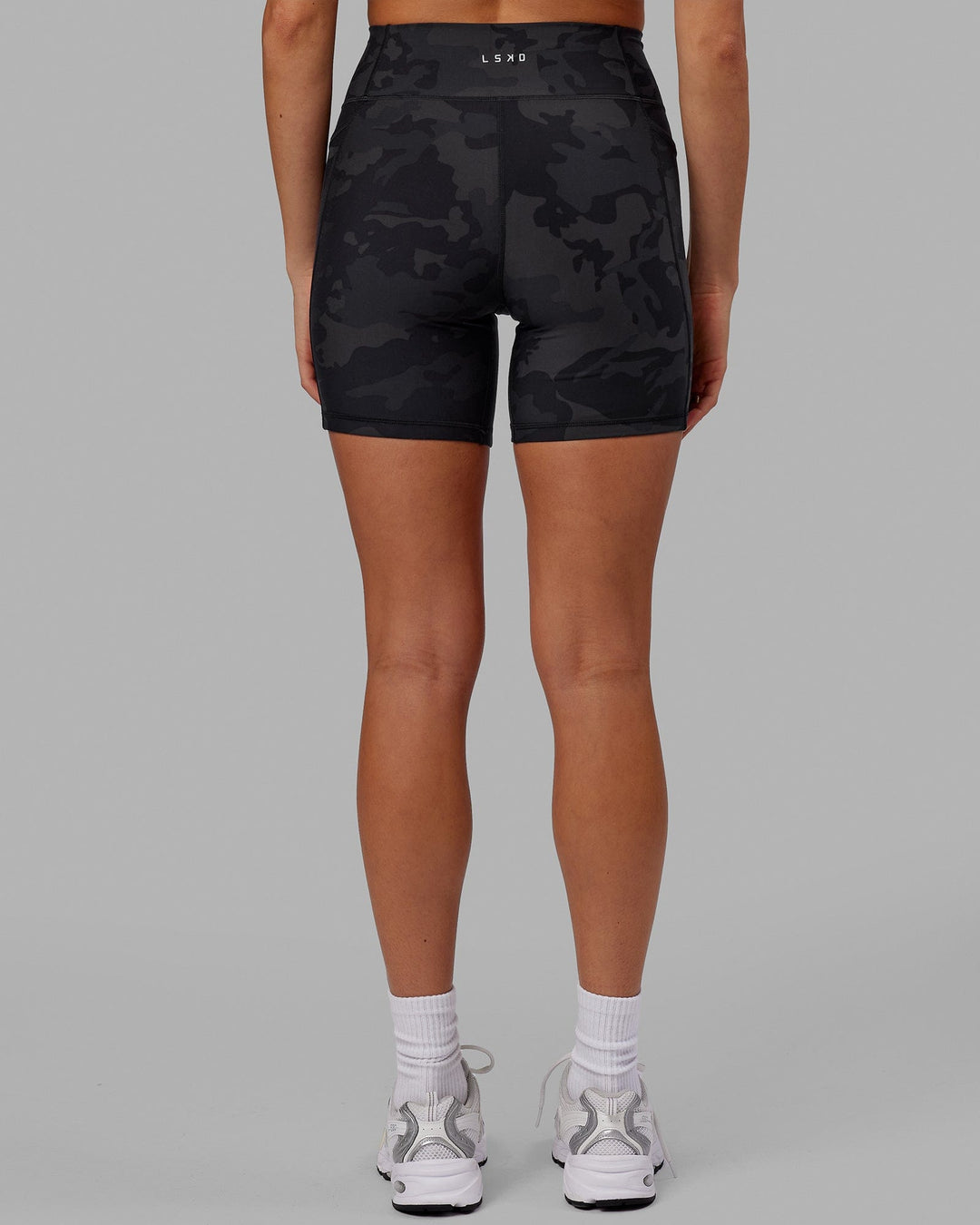 Woman wearing Fusion Ultra High-Rise 6" Short Pockets - Black Camo | Set:true | Angle:back | Model:Katie | Size:S